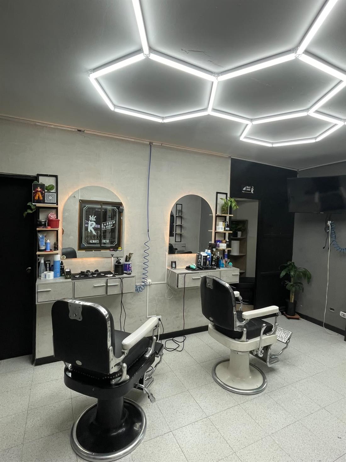 Interior con techo de luces hexagonales, espejos en arco y sillas clásicas